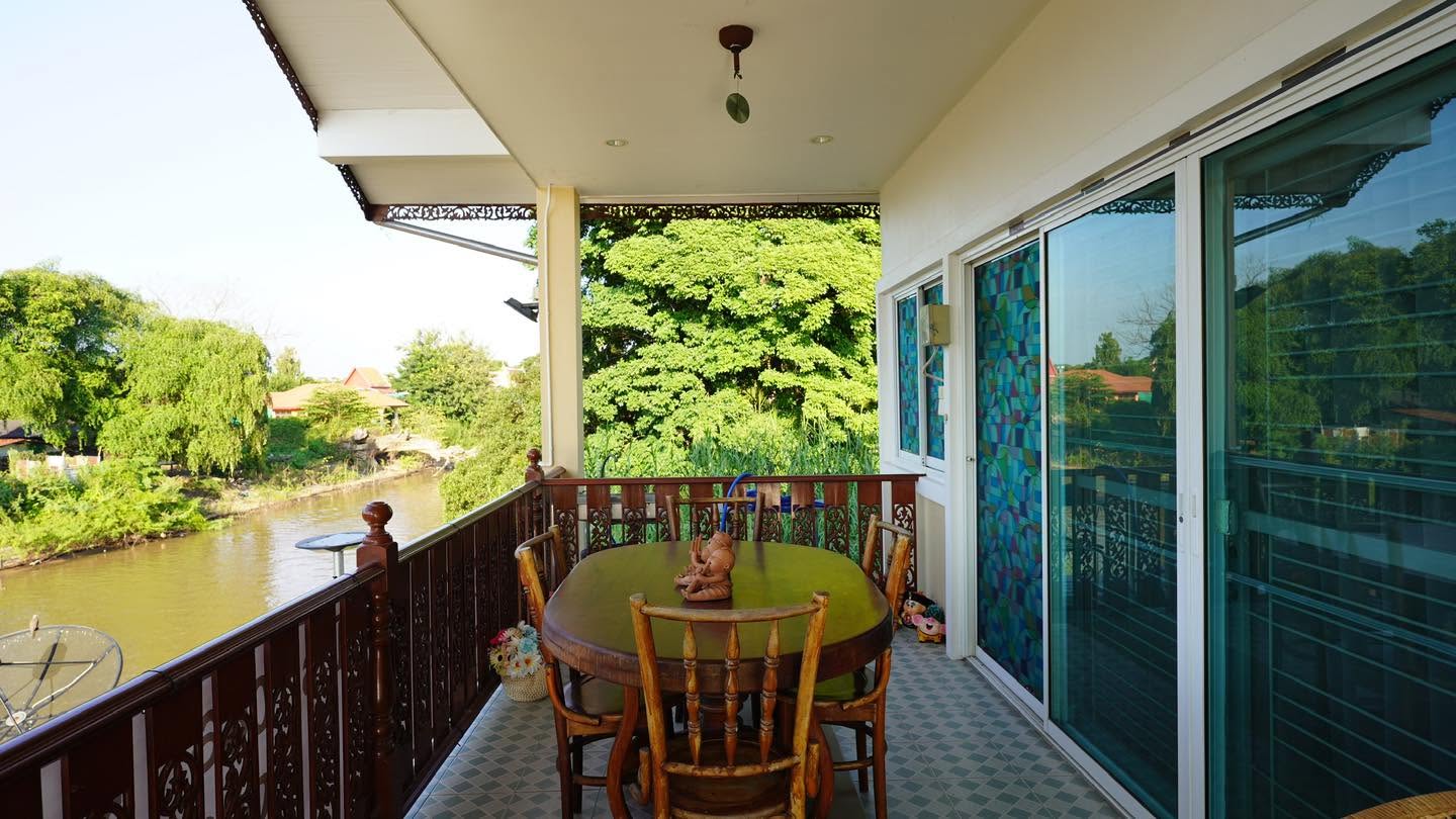 ระเบียงริมน้ำพร้อมโต๊ะไม้ของ Nadda's Homestay